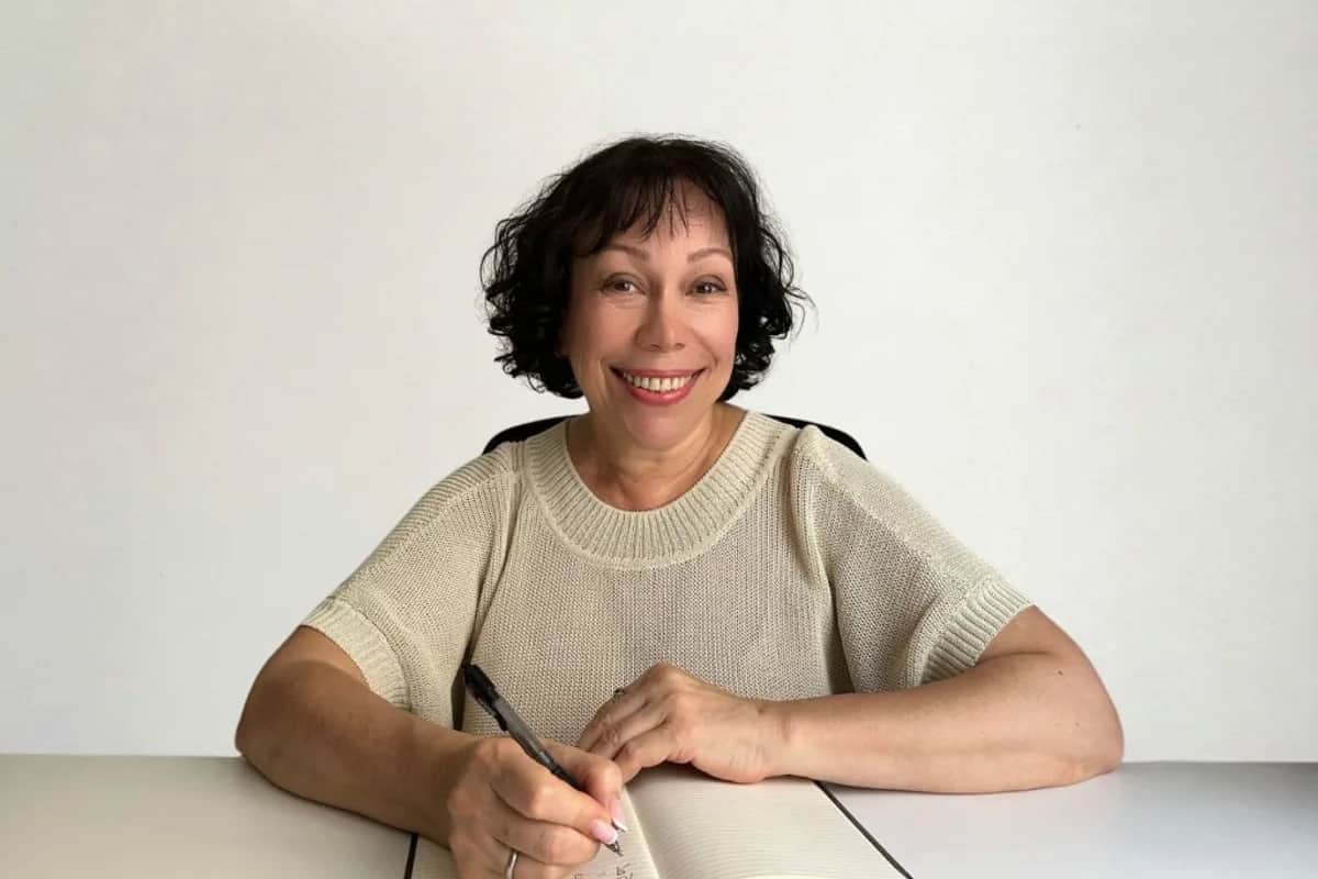 Tatiana Ivanova, profesora de ruso online, en su mesa de trabajo con cuaderno y planta