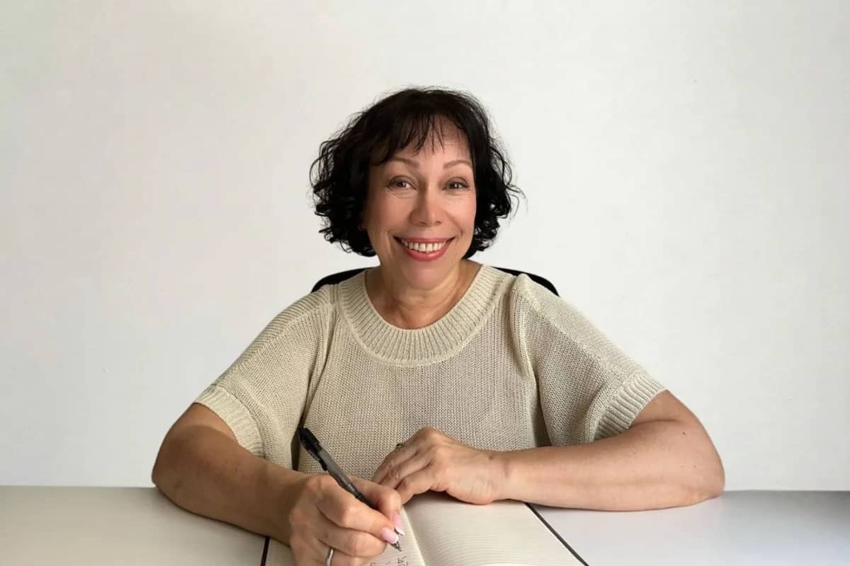 Tatiana Ivanova, profesora de ruso online, en su mesa de trabajo con cuaderno y planta